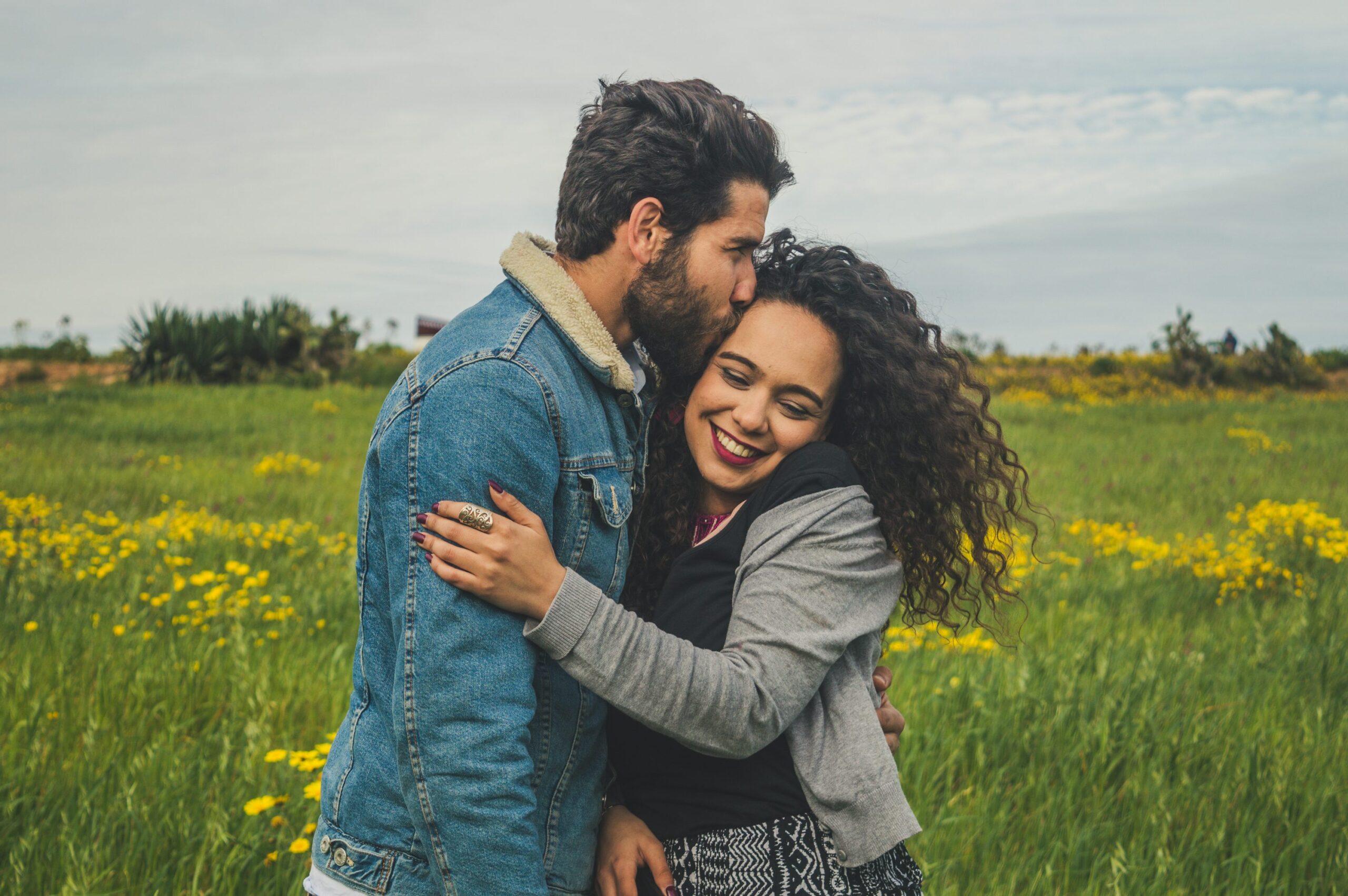 緑の草原で女性の頭にキスをする男