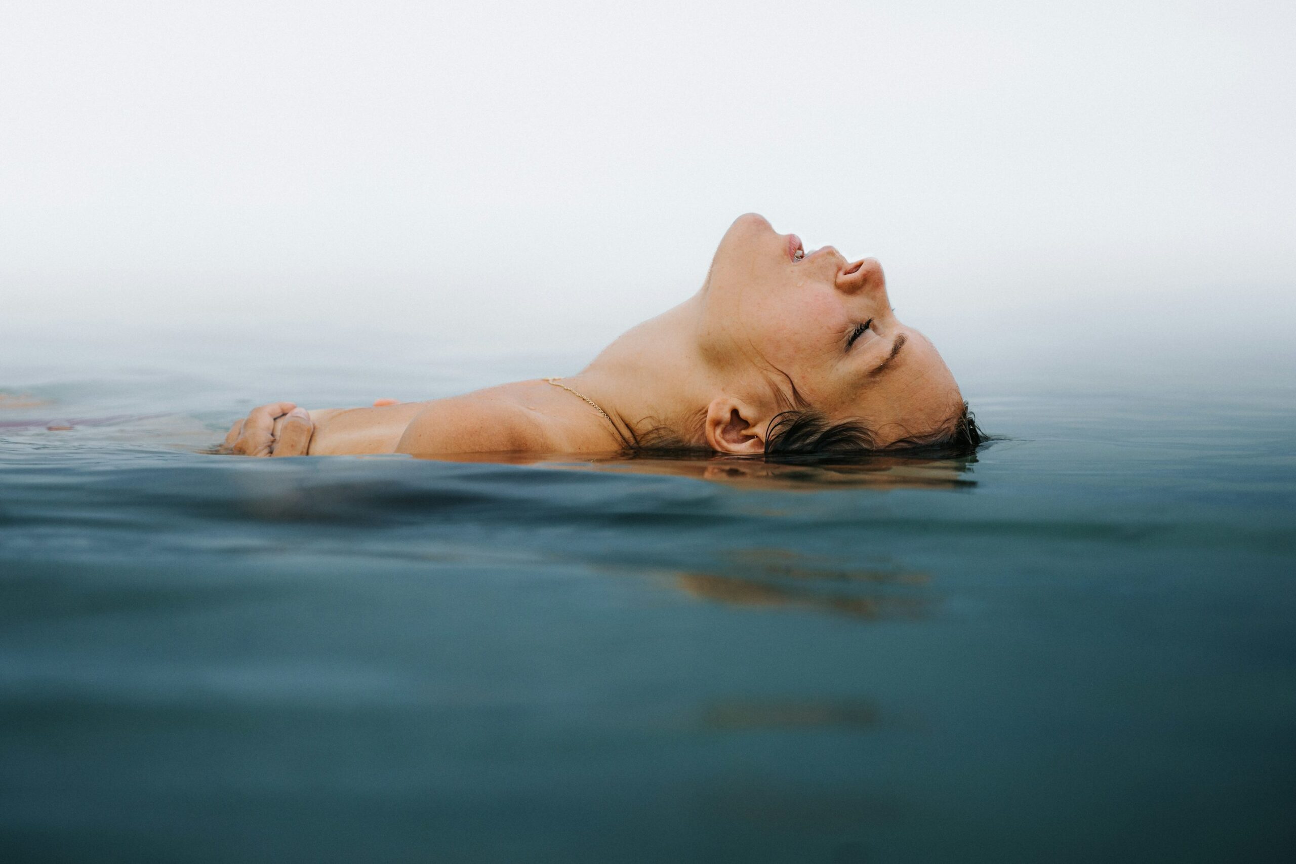 水域の上に浮かぶ女性