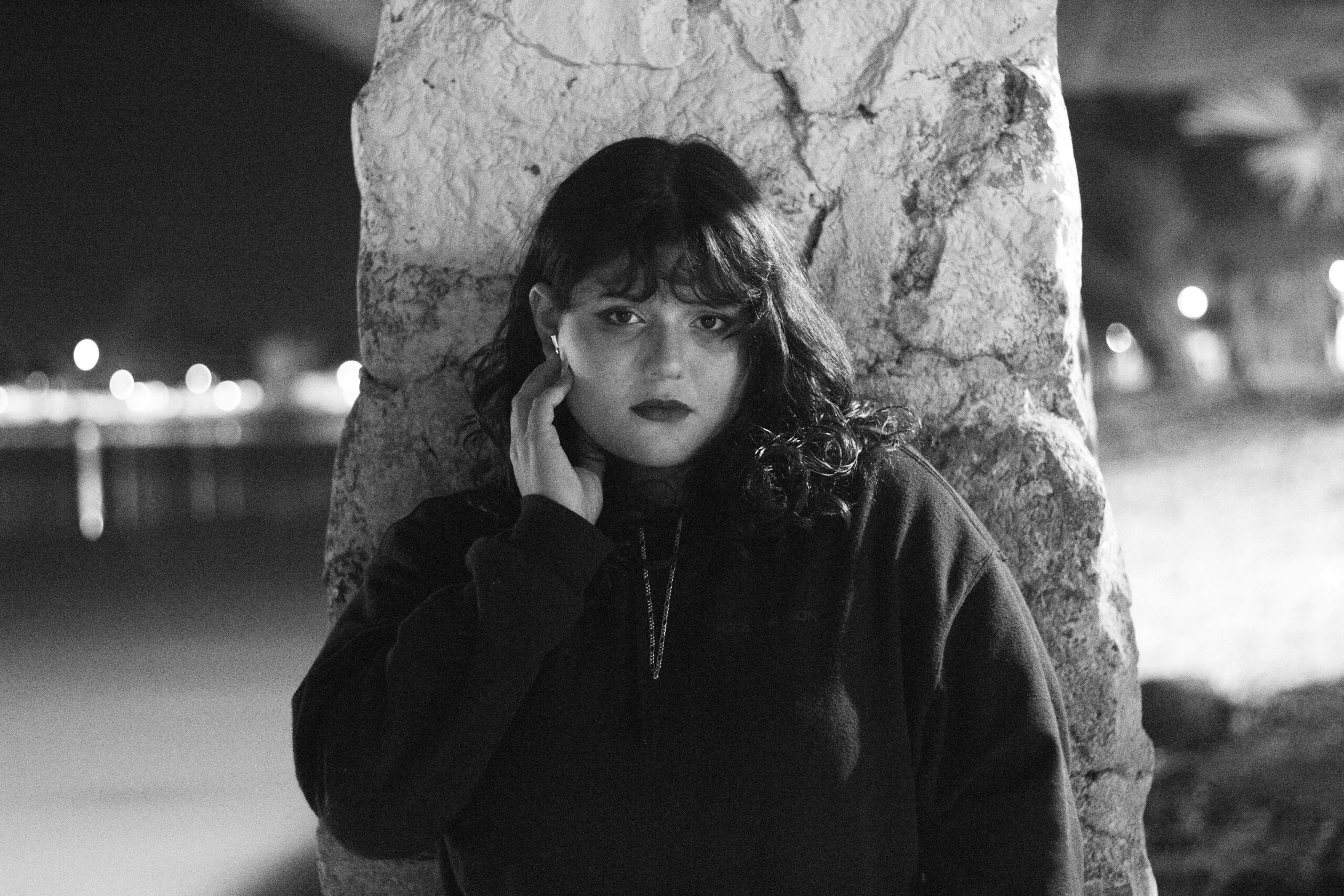 夜、石柱にもたれかかっている女性。